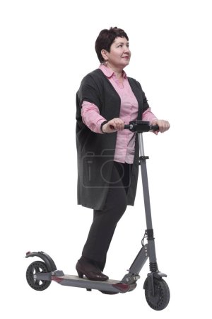 Foto de En pleno crecimiento. mujer madura con confianza con un scooter eléctrico. aislado sobre un fondo blanco - Imagen libre de derechos