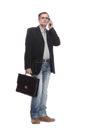 Téléchargez les photos : En pleine croissance. homme d'affaires sérieux avec un smartphone. isolé sur un fond blanc. - en image libre de droit