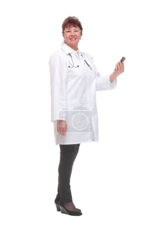 Foto de Vista lateral de la doctora sosteniendo el teléfono inteligente respondiendo a los pacientes sobre fondo blanco. Concepto de consulta médica en línea. - Imagen libre de derechos
