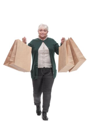 Photo for Happy senior woman stretching out hands with shopping bags and smiling while standing isolated on white background. I love shopping - Royalty Free Image