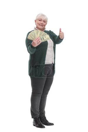 Foto de Alegre señora madura sosteniendo un par de pilas de dinero y mirando a la cámara aislada sobre fondo blanco - Imagen libre de derechos