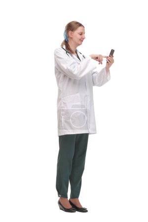 Téléchargez les photos : Portrait de femme médecin utilisant son téléphone portable dans la consultation. Isolé sur fond blanc - en image libre de droit