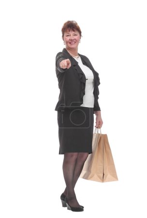Téléchargez les photos : Vue de face d'une femme ravie avec pouce levé tenant des sacs à provisions sur un fond blanc - en image libre de droit