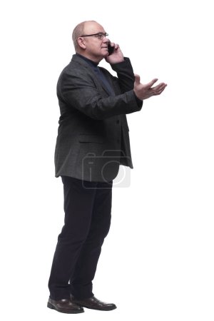 Photo for In full growth. business man talking on a smartphone . isolated on a white background - Royalty Free Image