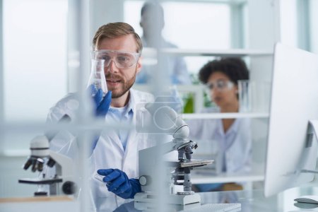 Téléchargez les photos : Scientifique masculin concentré travaillant en laboratoire - en image libre de droit