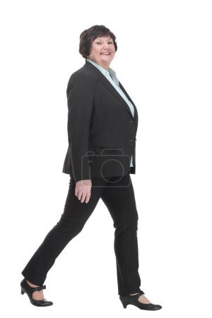 Photo for Mature business woman in a pantsuit striding forward. isolated on a white background. - Royalty Free Image