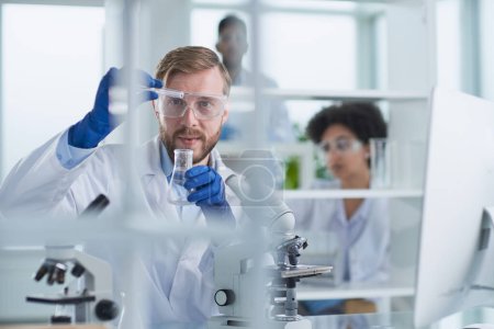 Téléchargez les photos : Scientifique masculin concentré travaillant en laboratoire - en image libre de droit