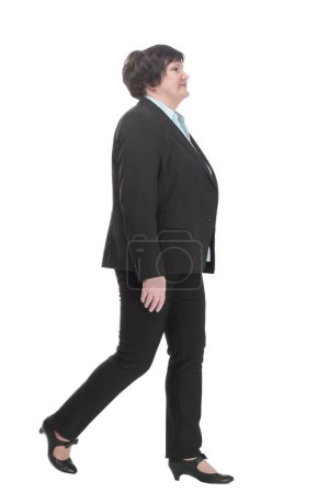 Foto de Mujer de negocios madura en un traje de pantalón que camina hacia adelante. aislado sobre un fondo blanco. - Imagen libre de derechos