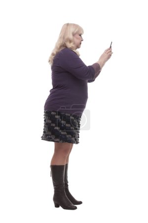 Téléchargez les photos : Sur toute la longueur. femme mature décontractée avec un smartphone. isolé sur un fond blanc. - en image libre de droit