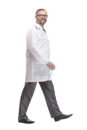 sur toute la longueur. Homme mûr médecin marche vers l'avant. isolé sur un fond blanc.