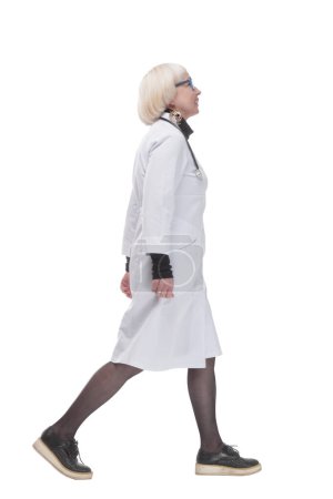 Téléchargez les photos : Sur toute la longueur. femme amicale médecin marche vers l'avant. isolé sur un fond blanc. - en image libre de droit
