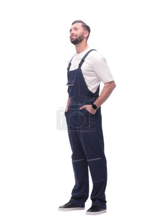 Photo for In full growth. smiling man in overalls looking at copy space. isolated on white background - Royalty Free Image