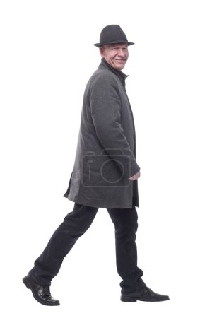Foto de En pleno crecimiento. un hombre inteligente en un abrigo de otoño que camina hacia adelante. aislado sobre un fondo blanco. - Imagen libre de derechos