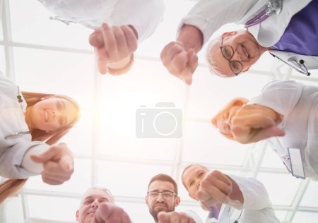 close up. group of doctors standing in a circle and pointing at you . photo with a copy-space