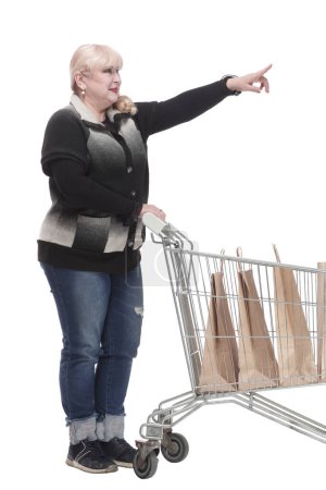 Foto de De larga duración. mujer casual en jeans con carrito de compras. aislado sobre un fondo blanco. - Imagen libre de derechos