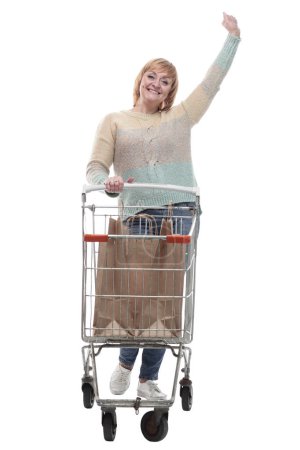 Foto de En pleno crecimiento. atractiva mujer casual con carrito de compras. aislado sobre un fondo blanco. - Imagen libre de derechos