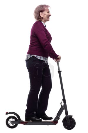 Téléchargez les photos : Vue latérale. sympathique femme âgée sur un scooter électrique. isolé sur un blanc - en image libre de droit