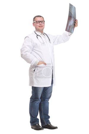 Photo for Side view of attractive doctor examining an x-ray and looking at the camera with positive - Royalty Free Image