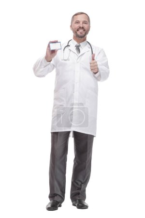 Photo for In full growth. smiling doctor showing his visiting card . isolated on a white background. - Royalty Free Image