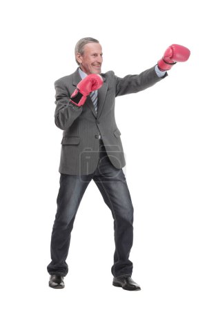 Foto de Hombre mayor caucásico serio en traje formal de negocios con guantes de boxeo golpeando. Aislado sobre fondo blanco - Imagen libre de derechos