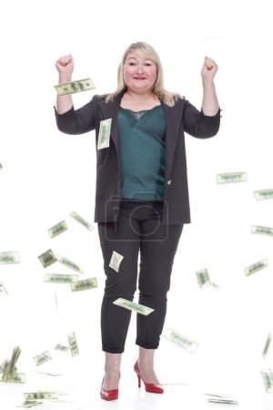 in full growth. attractive plump woman standing in the rain of banknotes. isolated on a white background.