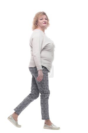 Téléchargez les photos : Femme décontractée dans un pull et pantalon marchant vers l'avant. isolé sur un fond blanc. - en image libre de droit