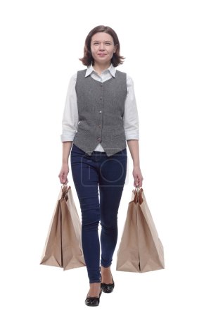 casual mature woman with shopping bags striding forward . isolated on a white background. Stickers 649684272