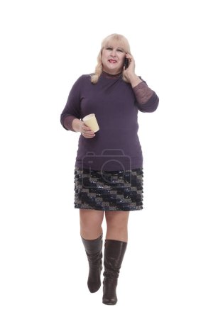 Foto de Mujer madura casual con teléfono inteligente y café para llevar. aislado sobre un fondo blanco. - Imagen libre de derechos