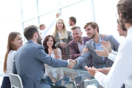 Foto de Gente de negocios dándose la mano sentados en el escritorio de la oficina. concepto de cooperación - Imagen libre de derechos