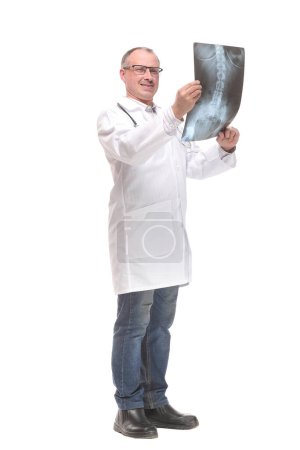 Téléchargez les photos : Vue de face d'un médecin avec stéthoscope étudiant l'image radiographique. Isolé sur fond blanc - en image libre de droit