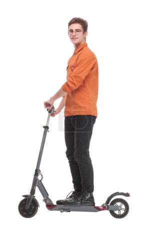 Foto de Retrato de vista lateral de cuerpo entero de un joven montado en un scooter y con aspecto de awawy aislado sobre fondo blanco - Imagen libre de derechos