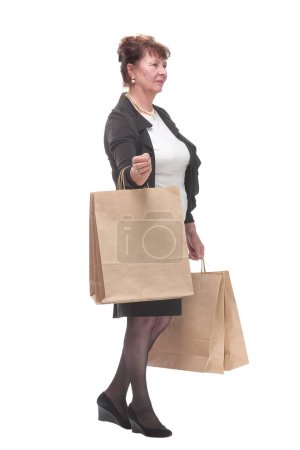 Photo for Side view portrait of happy senior woman posing with her shopping bag looking at camera and smiling - Royalty Free Image