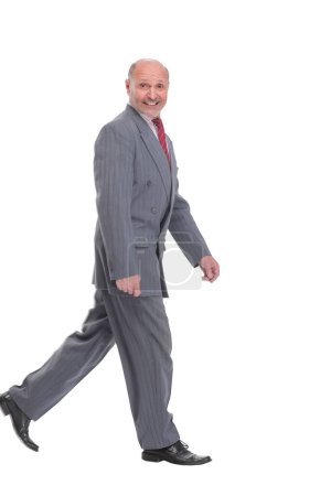 Photo for Side view full length photo of a mid aged business man walking forward and looking away. isolated on a white background - Royalty Free Image