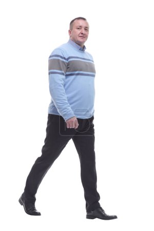 Foto de Vista lateral. un hombre serio en un suéter camina hacia adelante. aislado sobre un fondo blanco - Imagen libre de derechos