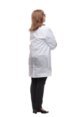 Téléchargez les photos : Vue latérale. Médecin féminine sérieuse regardant un écran blanc. isolé sur un fond blanc - en image libre de droit