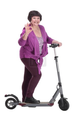 Téléchargez les photos : En pleine croissance.heureuse femme âgée avec scooter électrique. isolé sur un fond blanc. - en image libre de droit