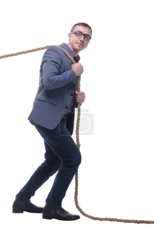 Foto de Vista lateral del hombre de negocios en traje tirando de una cuerda mientras está de pie sobre fondo blanco. Concepto de esfuerzos - Imagen libre de derechos