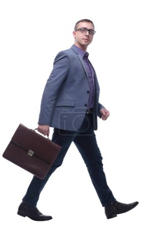 Téléchargez les photos : Vue latérale homme d'affaires tenant la mallette brève et marchant sur fond blanc - en image libre de droit