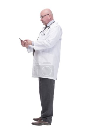 Photo for Full-length. mature doctor with smartphone. isolated on a white background. - Royalty Free Image