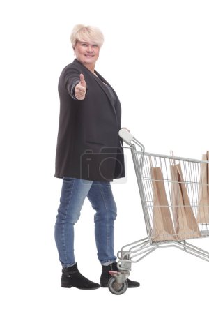 Photo for Full-length. casual mature woman with shopping cart . isolated on a white background. - Royalty Free Image