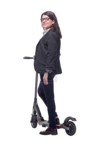 Foto de Retrato de cuerpo entero de una mujer montando un scooter aislado sobre fondo blanco y apuntando a la cámara - Imagen libre de derechos