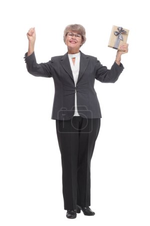 Téléchargez les photos : Full body senior woman happy and smiling, holding a gift and pointed on it looking at camera - en image libre de droit