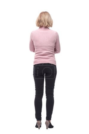 Téléchargez les photos : Vue arrière de la femme blonde debout en jeans et pull isolé sur fond blanc - en image libre de droit