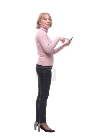 Foto de Vista lateral de la bella dama mirando la pantalla de su teléfono celular y de pie sobre fondo blanco - Imagen libre de derechos