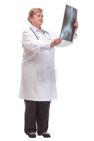Téléchargez les photos : Vue de face d'une femme médecin portant un stéthoscope et des lunettes regardant une radiographie. Concept d'aide médicale - en image libre de droit