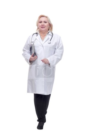 Photo for Portrait of attractive female doctor walking with clipboard and smiling at camera. - Royalty Free Image