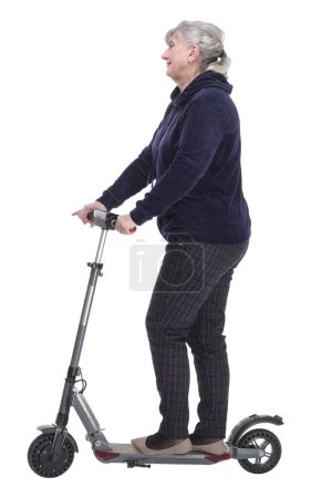 Foto de Vista lateral. anciana con un scooter eléctrico mirando a una pantalla blanca. aislado sobre un fondo blanco. - Imagen libre de derechos