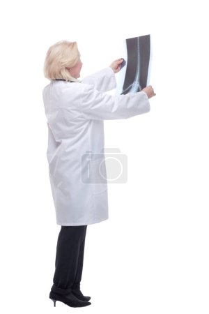 Side view of young professional female doctor examining patients x-ray of human spine during a visit
