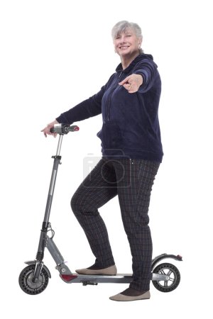 Photo for Side view. smiling elderly woman with an electric scooter looking at you . isolated on a white background. - Royalty Free Image