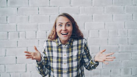 Photo for Portrait of happy and excited young woman smiling, laughing, opening mouth and touching face expressing excitement and happiness. Good news and positive emotions concept. - Royalty Free Image